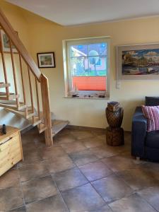 een woonkamer met een trap en een raam bij Ferienhaus zur Kranichweide in Bodstedt