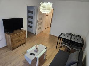 a living room with a couch and a tv at Justinrent Rynek 36 in Legnica