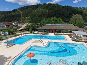 a large swimming pool in front of a mountain at Pension am Brunnenbach in Sulz am Neckar