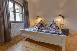 a bed with two pillows on it in a room at Das Backsteinhus, App Achtern Diek in Dargen