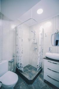 een badkamer met een douche, een toilet en een wastafel bij Apartment Serpoint in Tbilisi City