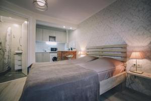 een slaapkamer met een groot bed en een keuken bij Apartment Serpoint in Tbilisi City