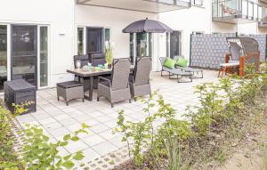 un patio avec une table, des chaises et un parasol dans l'établissement Haus Zudar FeWo 03 Ferien-Ankerplatz in Prora", à Prora