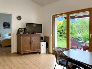 a living room with a television and a table and chairs at Ferienhaus Gamssteige im Feriendorf Reichenbach G24a in Nesselwang +7 photos