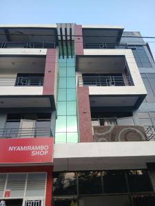 a tall building with a sign in front of it at Umwezi apartment in Kigali