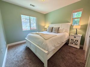 a bedroom with a white bed and two windows at Filbert Reserve in Paso Robles