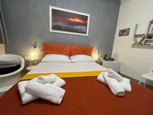 una camera da letto con un letto grande con asciugamani sopra di Gianluca Home a Catania
