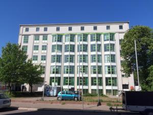 a white building with a blue car parked in front of it at Apartmenthaus in Halle-Saale nähe Hauptbahnhof in Halle an der Saale