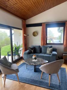 a living room with a blue couch and a table at Ferienhaus Gamssteige im Feriendorf Reichenbach G6 in Nesselwang