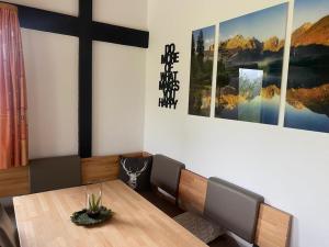 a dining room with a table and a cross on the wall at Ferienhaus Gamssteige im Feriendorf Reichenbach G6 in Nesselwang +6 photos