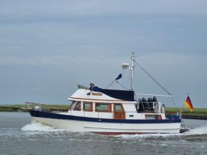 a boat in the water with a flag on it at Seewolf in Cuxhaven