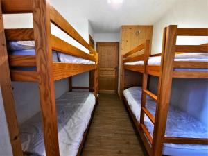 a room with three bunk beds in a house at Appartement cosy, 6 pers., pieds des pistes, 2 chambres, balcon sud-ouest, quartier Reberty 1850 - FR-1-452-16 in Les Menuires