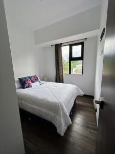 a bedroom with a large bed with a window at Apartamento con Piscina de 2 habitaciones Edificio Brunelo Ciudad de Guatemala, Céntrico in Estación Pamplona +46 photos