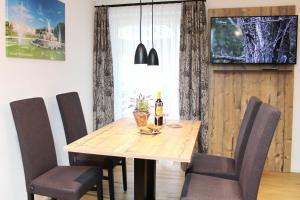 Una mesa de comedor con sillas y una botella de vino. en Seethal-Alpenrand, en Übersee