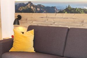almohada amarilla en el sofá de la sala de estar en Seethal-Alpenrand, en Übersee