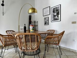 a dining room with a table and rattan chairs at Laguna in Palazzo Vianello