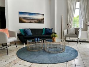 a living room with a black couch and two tables at Laguna in Palazzo Vianello