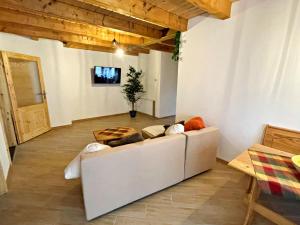 a living room with a white couch and a table at Dachdeckersruh in Zirchow