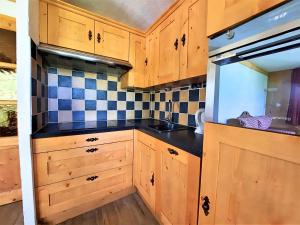 a kitchen with wooden cabinets and a sink at Appartement 6 personnes aux pieds des pistes, animaux admis - FR-1-452-4 in Les Menuires +8 photos