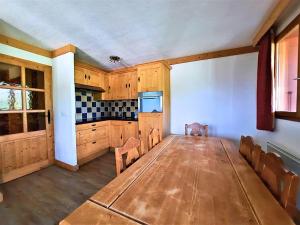 a large room with a table and a kitchen at Appartement 6 personnes aux pieds des pistes, animaux admis - FR-1-452-4 in Les Menuires