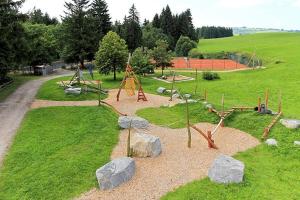 ネッセルヴァンクにあるFerienhaus Rehpfad im Feriendorf Reichenbach 17の滑り台や岩のある遊び場がある公園