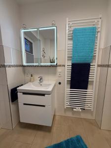 a bathroom with a sink and a mirror and a towel at Ferienwohnungen Heimathafen und Hafenkante in Neustadt in Holstein