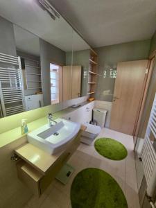 een badkamer met een wastafel, een toilet en een spiegel bij Premium Apartment Vilsonovo in Sarajevo