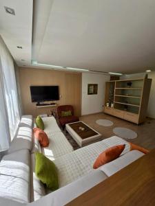 een woonkamer met twee witte banken en een televisie bij Premium Apartment Vilsonovo in Sarajevo