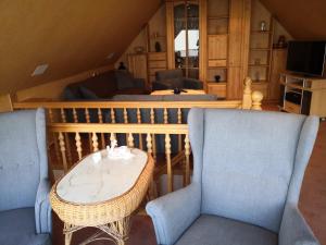a living room with two chairs and a table at Freude Reetgedecktes Ferienhaus in Ueckeritz