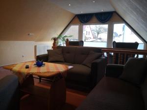 a living room with a couch and a table at Freude Reetgedecktes Ferienhaus in Ueckeritz