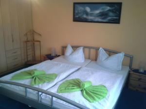a bed with two green bow pillows on it at Freude Reetgedecktes Ferienhaus in Ueckeritz