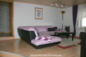 a living room with a couch and a chair at Ferienwohnung Hamel in Kirchlotheim +11 photos
