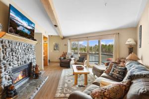 a living room with a large stone fireplace at Tahoe Keys Marina View - 3 BDR Desirable Community in South Lake Tahoe