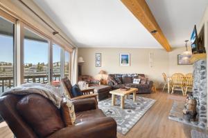 a living room with leather furniture and a large window at Tahoe Keys Marina View - 3 BDR Desirable Community in South Lake Tahoe