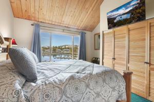 a bedroom with a large bed and a large window at Tahoe Keys Marina View - 3 BDR Desirable Community in South Lake Tahoe