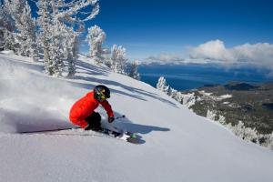 a person riding a snowboard down a snow covered slope at Tahoe Keys Marina View - 3 BDR Desirable Community in South Lake Tahoe