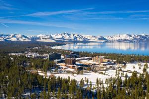 an aerial view of a resort on a lake with snow covered mountains at Tahoe Keys Marina View - 3 BDR Desirable Community in South Lake Tahoe
