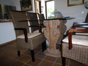 a dining room table with wicker chairs and a glass top at Ottavia in Caleri