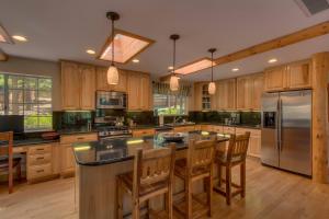 a large kitchen with wooden cabinets and stainless steel appliances at Prima Del Norte - Hot tub Pool Table Arcade Game in South Lake Tahoe +33 photos