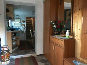 a kitchen with wooden cabinets and a counter with flowers at Csajka FeWo in Ueckeritz +4 photos