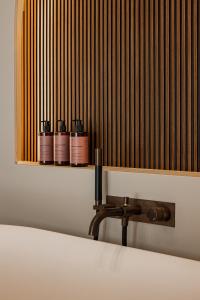 a shelf with four bottles on top of a bed at PATHOS Private Villas - Adults Only in Samos
