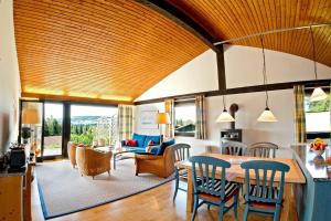 a kitchen and living room with a table and chairs at Ferienhaus Gamssteige im Feriendorf Reichenbach G21 in Nesselwang +12 photos