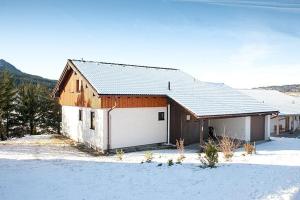 a barn with a white door in the snow at Ferienhaus Gamssteige im Feriendorf Reichenbach G12 in Nesselwang