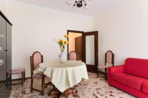 カターニアにあるアパルタメント バカンツィ カターニアのリビングルーム(テーブル、赤いソファ付)