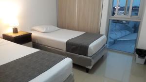 a hotel room with two beds and a window at Espacio Confortable y Agradable, Atlantis in Santa Cruz de la Sierra