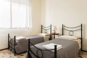 een slaapkamer met twee bedden en een raam bij Appartamenti Catania Centro in Catania