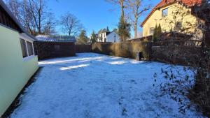 einen schneebedeckten Hof vor einem Haus in der Unterkunft Ferienhaus am Müritz Nationalpark in Waren (Müritz)