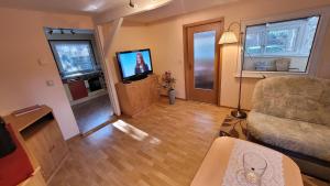 ein Wohnzimmer mit Sofa und Fernseher in der Unterkunft Ferienhaus am Müritz Nationalpark in Waren (Müritz) + 12 Fotos