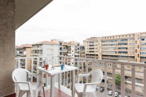 een balkon met een tafel en stoelen en gebouwen bij Appartamenti Catania Centro in Catania