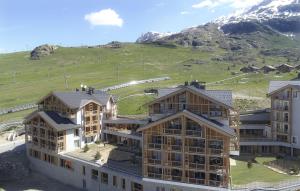 eine Gruppe von Gebäuden mit einem Berg im Hintergrund in der Unterkunft Résidence Phoenix B by Leavetown Vacations in L'Alpe-d'Huez